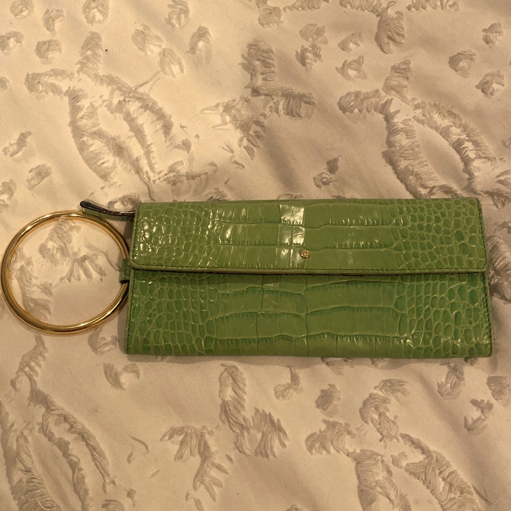 Green crocodile Kate Spade clutch with gold ring.